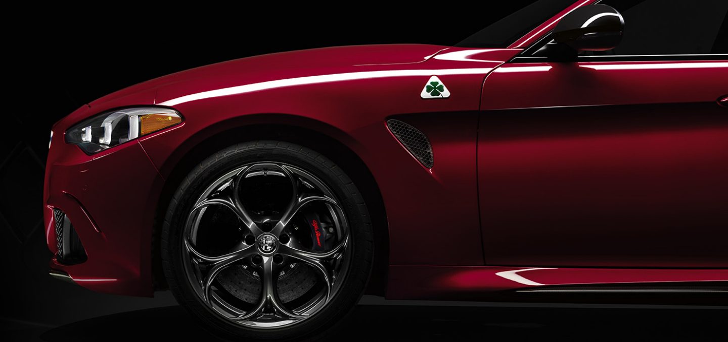 Mostrar Perfil parcial del lado del conductor —desde el extremo frontal hasta el final de la puerta del conductor— de un Alfa Romeo Giulia Quadrifoglio 2024 rojo.