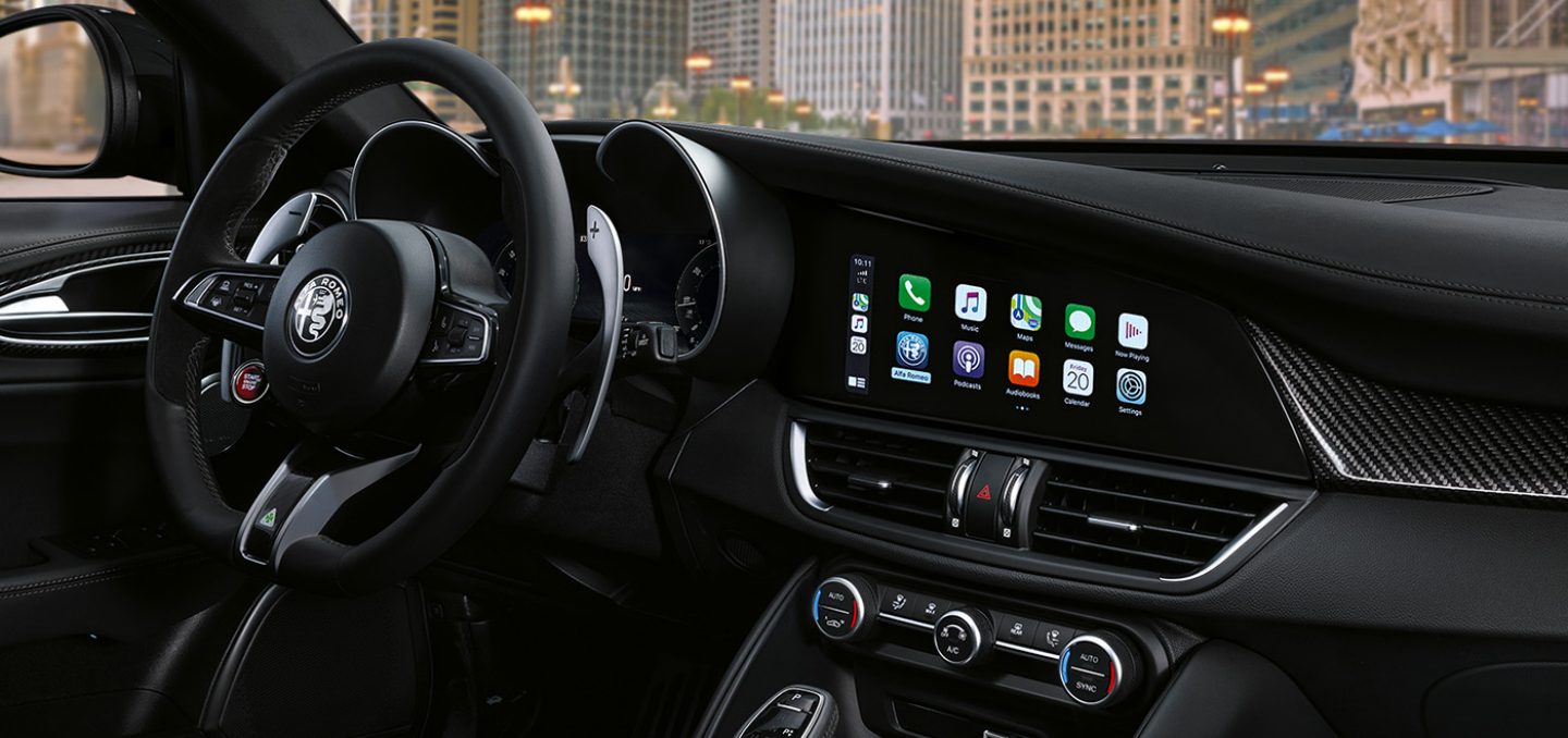 Mostrar Primer plano del volante, el panel central y la pantalla multitáctil en el Alfa Romeo Giulia Quadrifoglio 2024.