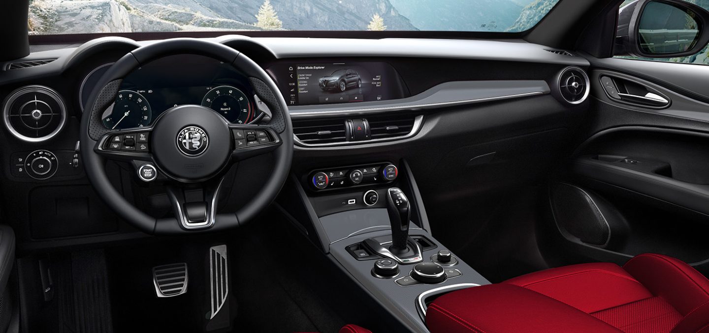 Mostrar El interior del Alfa Romeo Stelvio TBD 2024 con foco en el volante, el panel de instrumentos digital con información para el conductor, la consola central y la pantalla multitáctil.