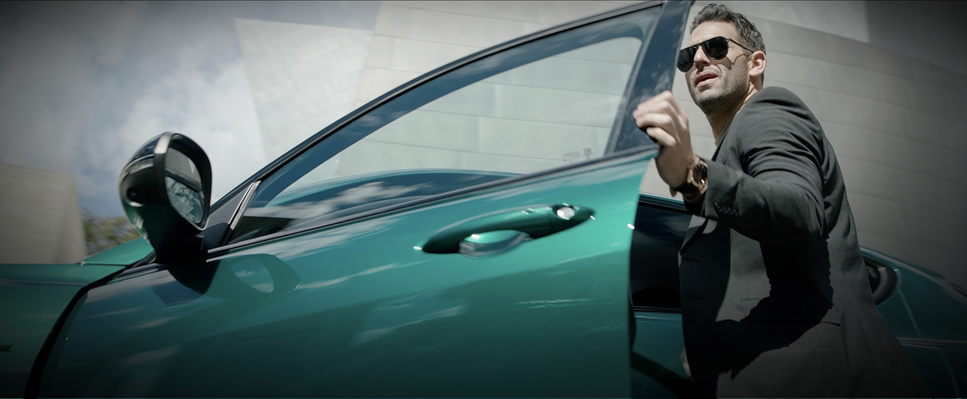 Un hombre abre la puerta del conductor de Alfa Romeo Tonale 2024 verde.